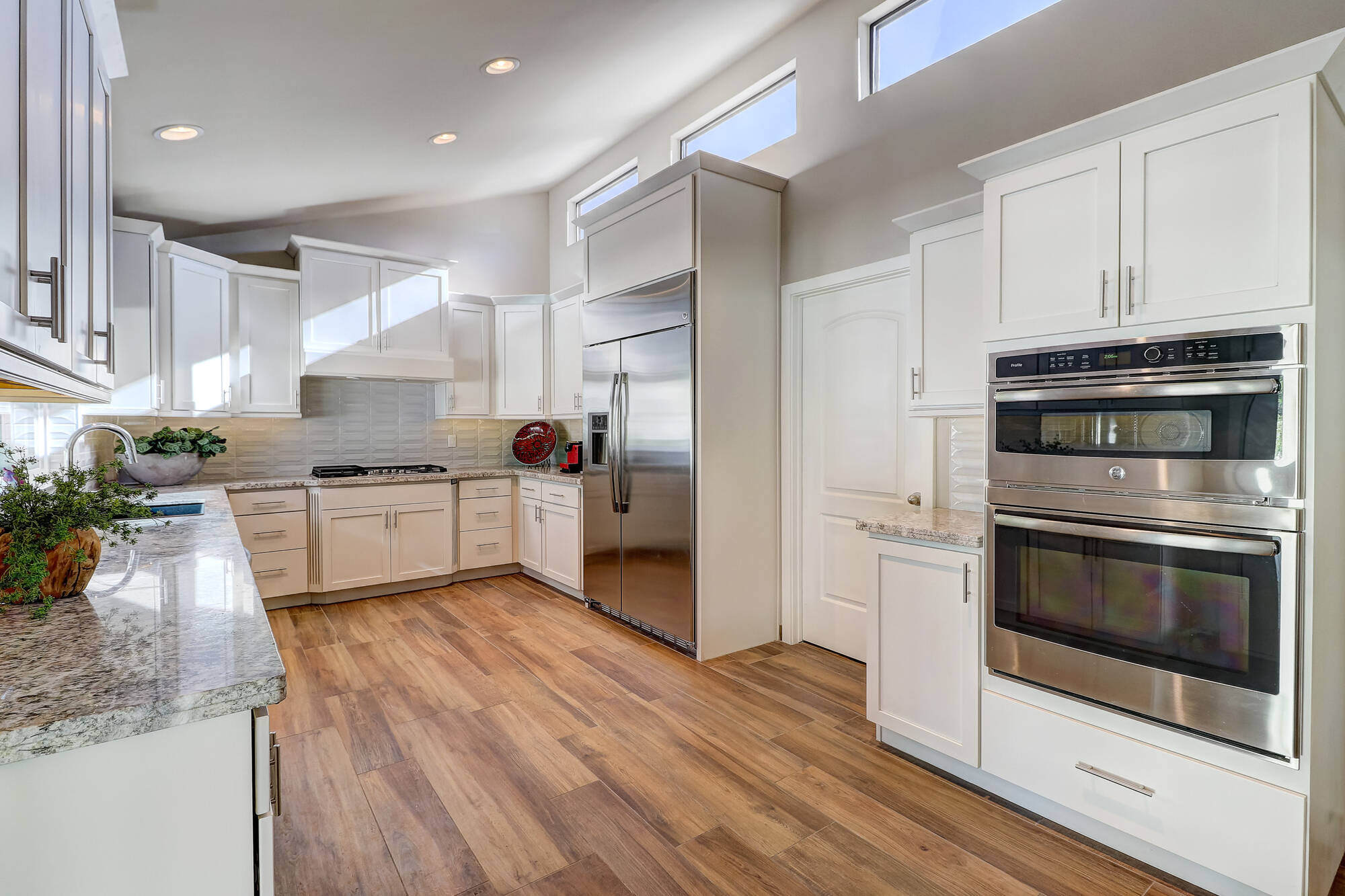 Bright white kitchen with stainless steel appliances in a custom home by MGD Builders, Phoenix, AZ