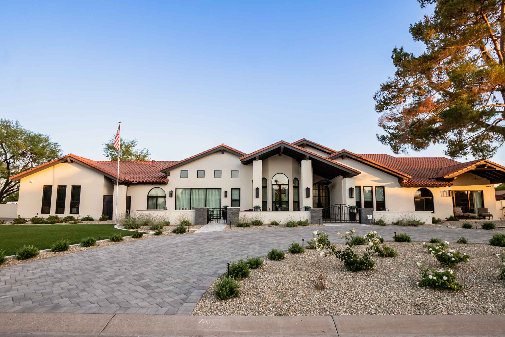 Front view of a custom home with red-tile roof built by MGD Builders in Phoenix, AZ, featuring an American flag