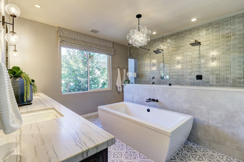 Spacious bathroom with a freestanding bathtub and glass shower, remodeled by MGD Builders, Phoenix