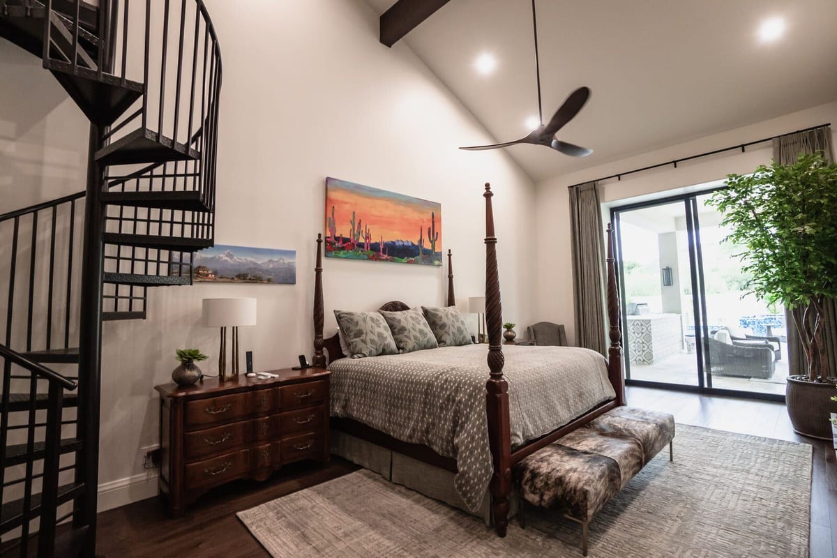 Custom bedroom featuring a spiral staircase and colorful artwork in Phoenix home renovation by MGD Builders 