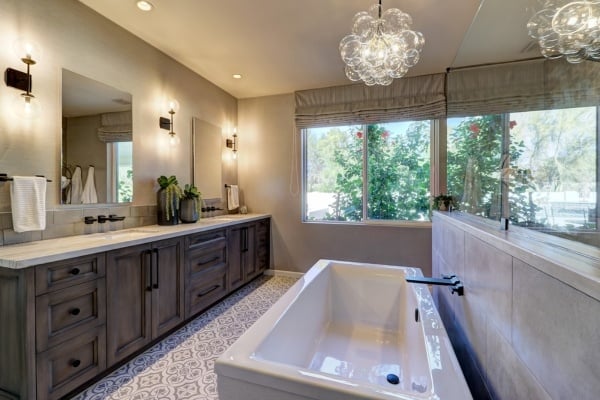 Elegant bathroom in a custom home by MGD Builders, Phoenix, AZ, with large mirrors and a soaking tub