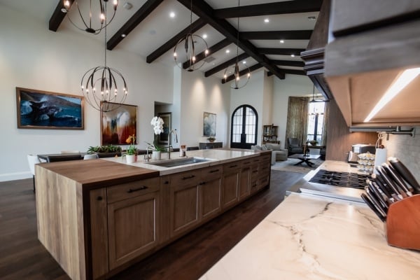 Open-concept kitchen with rustic wood island and modern lighting by MGD Builders, Phoenix, AZ