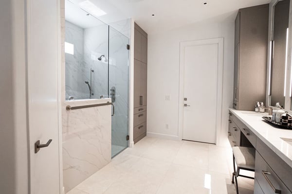 Modern bathroom in a Phoenix custom home by MGD Builders, featuring a glass-enclosed shower and sleek cabinetry