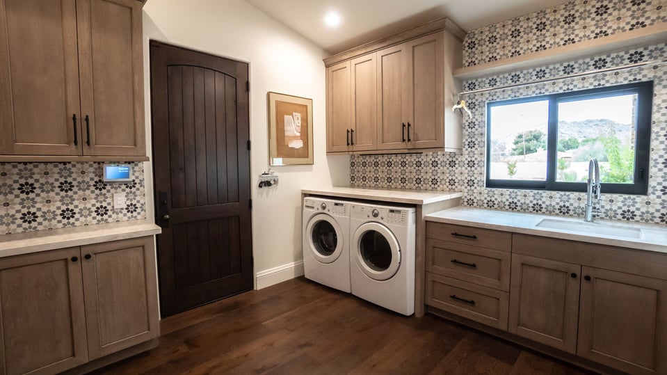 whole home remodel with laundry room renovation in phoenix az featuring wood floors, patterned backsplash, and ample cabinetry and storage