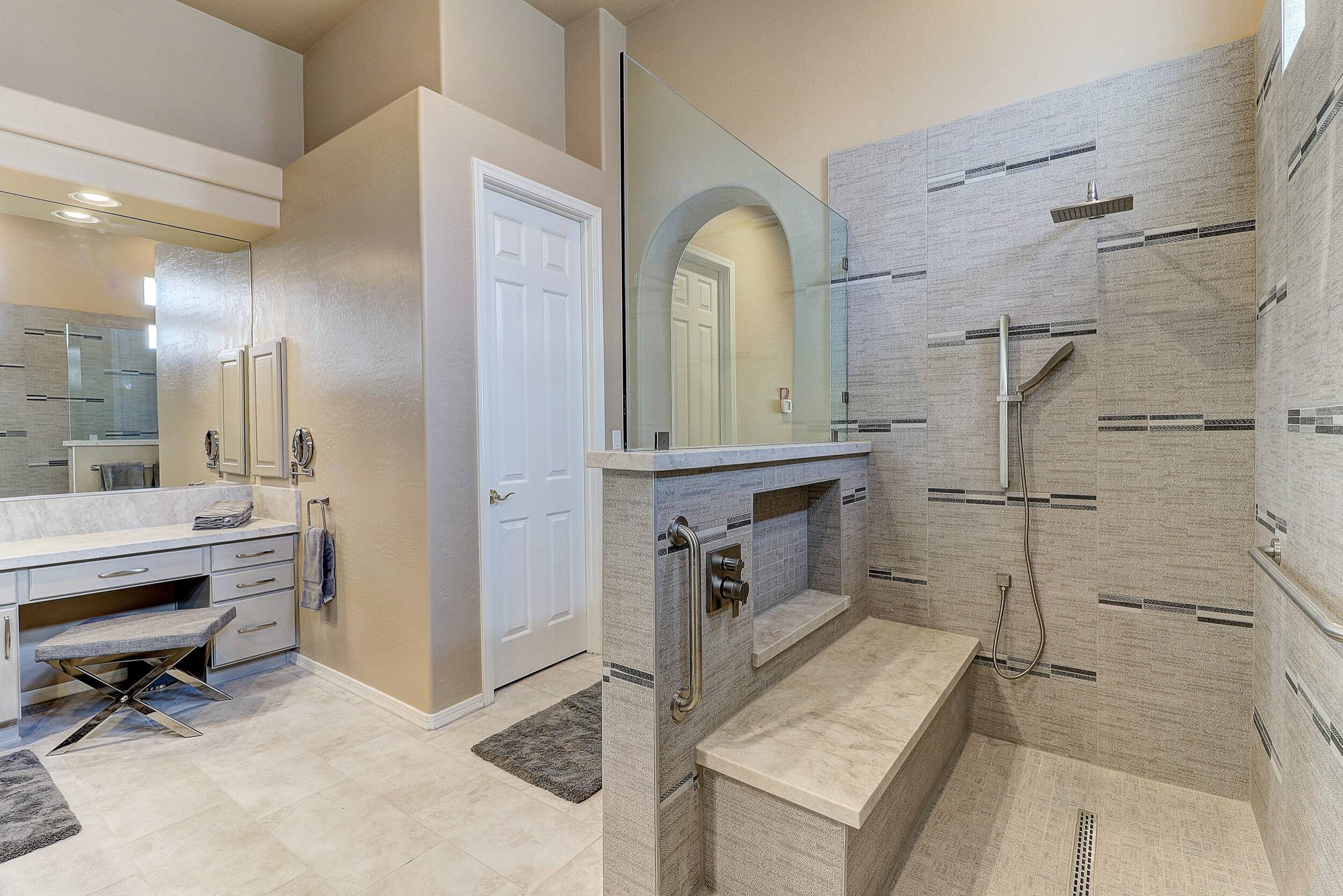 Contemporary bathroom featuring a spacious walk-in shower with beige and gray textured tiles.