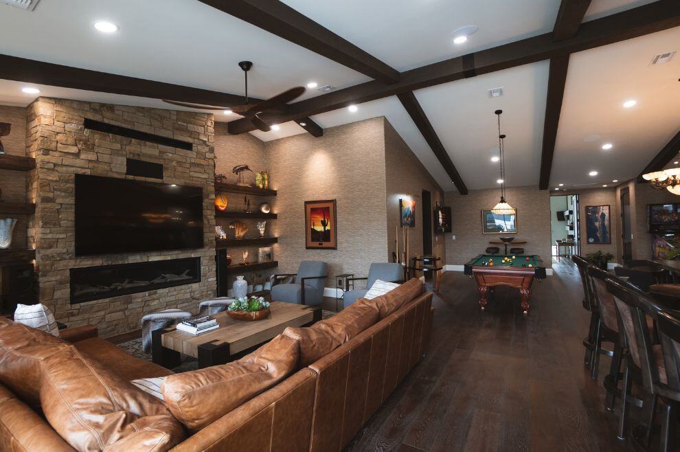 Basement remodel with stone fireplace, bar, pool table, and sectional couch