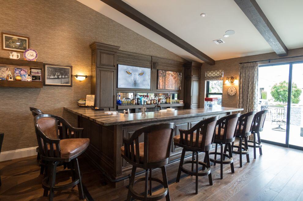 Custom home bar with bar stools and dark cabinets in Phoenix Arizona