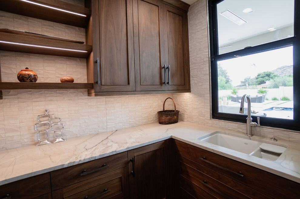 Kitchen pantry with cabinetry, shelving, and sink under window