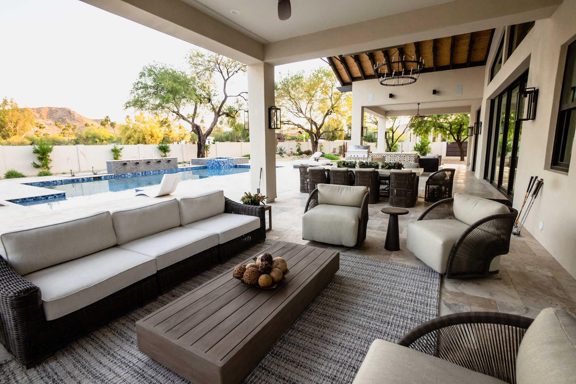 Covered patio with modern outdoor furniture next to a pool in a custom home by MGD Builders, Phoenix, AZ