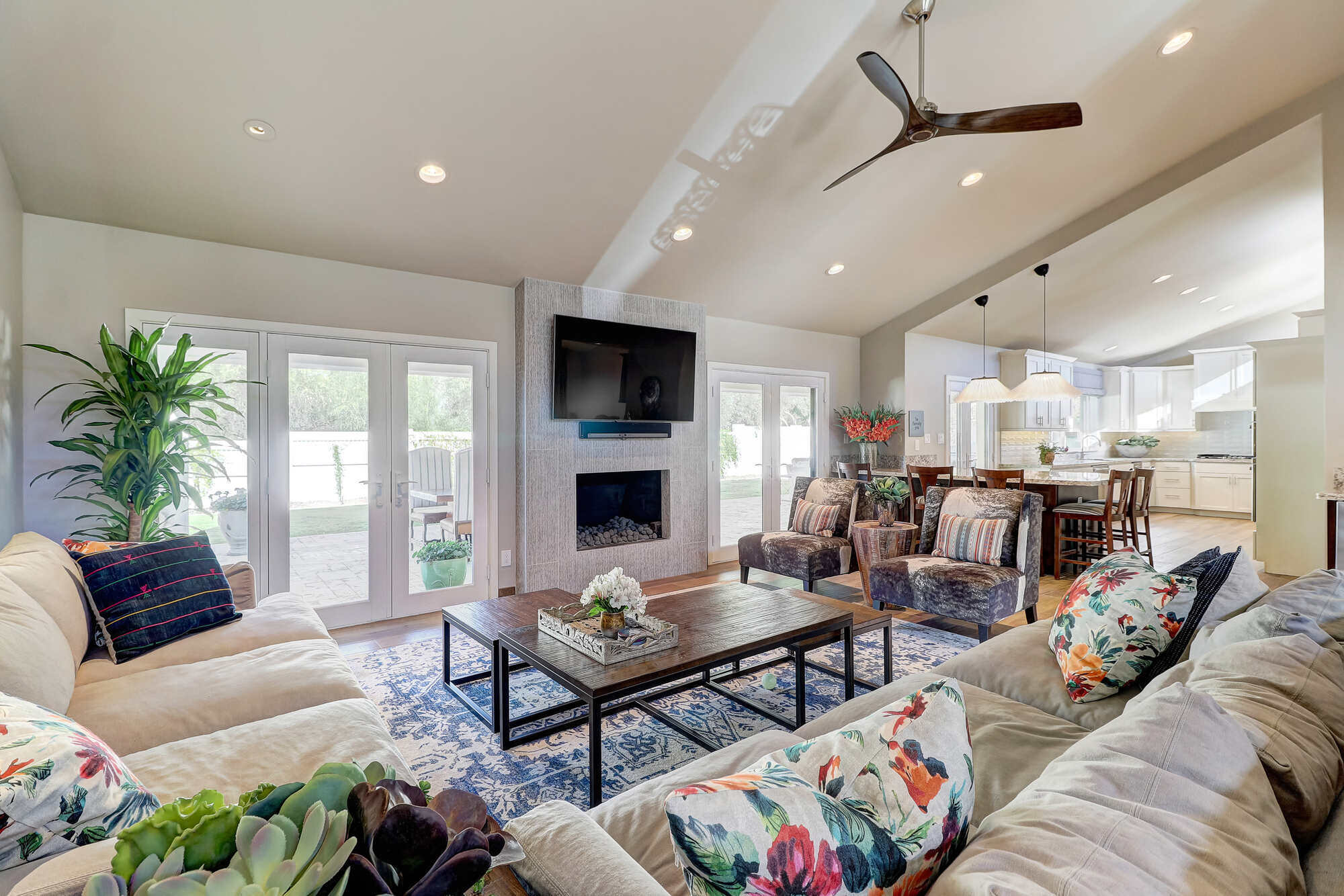 Modern living room with fireplace leading into the kitchen in a custom home built by MGD Builders, Phoenix, AZ