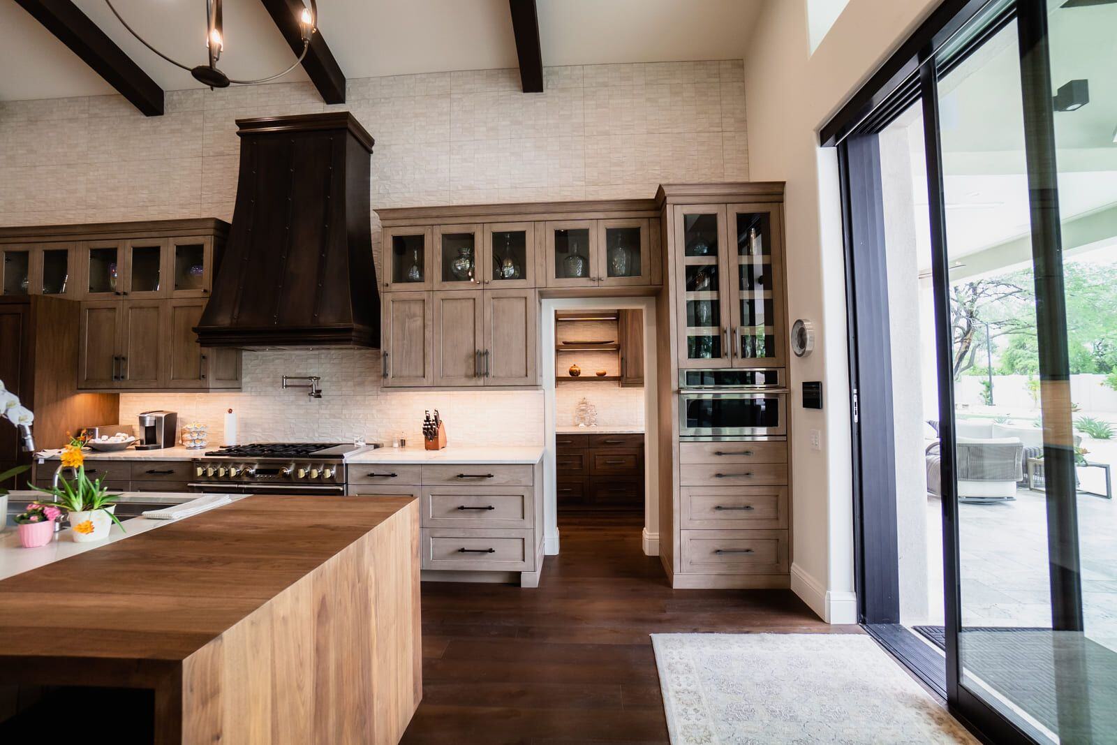 Spacious kitchen with wooden cabinets, large island, and view into pantry area, Mertel Whole Home Renovation, MGD Builders, Phoenix AZ 